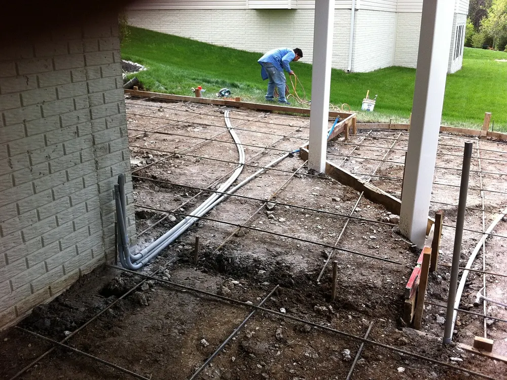Electrical conduit laid across a patio base before the concrete slab is poured